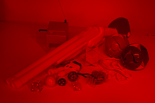 Red-lit assemblage of objects