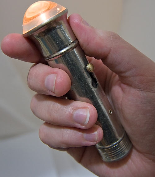 Old flashlight in hand